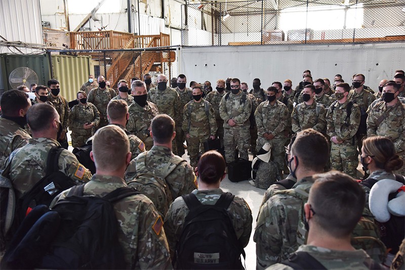 Maj. Gen. Jeff Holmes speaking to large group of Soldiers in a hanger after their return from deployment