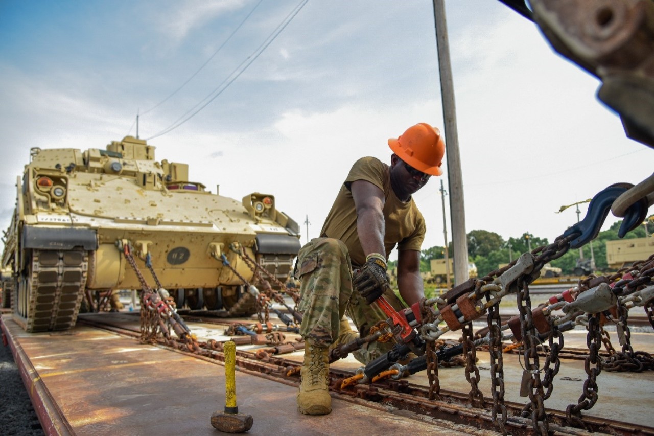 A Soldier assigned to the 278th Armored Cavalry Regiment loads a Bradley Fighting Vehicle onto a train in preparation for movement to Fort Hood, Texas, June 21. Approximately 1,000 vehicles, tanks and pieces of equipment are being loaded onto trains in preparation for XCTC, a three-week training exercise that will be taking place in Fort Hood over the summer. (Photo by Sgt. 1st Class Timothy Cordeiro)