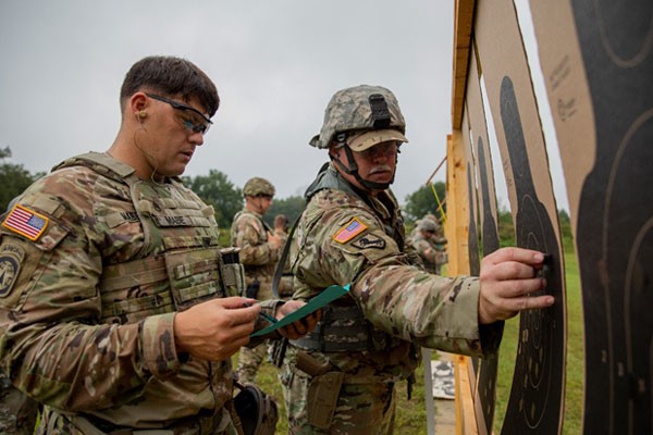 Tennessee National Guardsmen and Active Duty Army personnel work together to tally scores, Aug. 22, during the TAG Pistol Match at Tullahoma’s Volunteer Training Site. The TAG Match is an annual marksmanship competition and training event hosted by the Tennessee Combat Marksmanship Program. (Photo by Pfc. Olivia Gum)