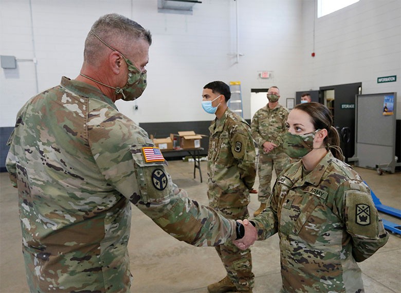Tennessee's Adjutant General, Maj. Gen. Jeff Holmes, presents Spec. Cheyanne Kyle, from Millington’s 268th Military Police Company, a commander’s coin for excellence at the Millington National Guard Armory on Jan. 8. She is one of more than 80 Soldiers preparing for a yearlong deployment that departed for Fort Bliss, Texas, on Jan. 10, to complete final mobilization training before traveling to the Horn of Africa in support of U.S. Africa Command. (photo by Staff Sgt. Mathieu Perry)