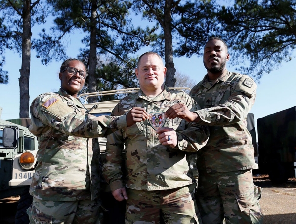 Spc. Daija Brunson, Sgt. 1st Class Jonathan Jones, and Spc. Christopher Williams hold a Shelby County Sheriff’s Office patch at the Millington National Guard Armory, Jan. 8. All three Soldiers are full-time deputies with the Shelby County Sheriff’s Office and members of the Tennessee National Guard’s 268th Military Police Company, based in Millington. They are three of more than 80 Soldiers who left Jan. 10, for a yearlong deployment to the Horn of Africa in support of U.S. Africa Command. (photo by Staff Sgt. Mathieu Perry)