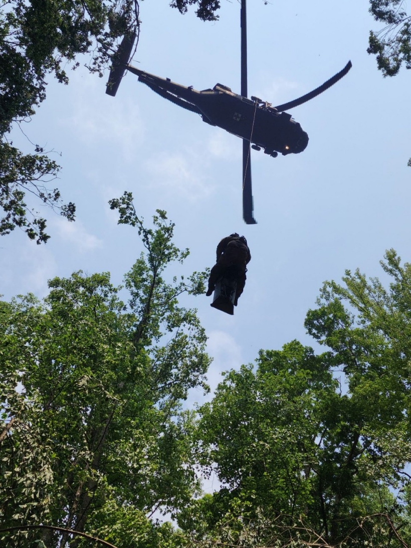An injured hiker and a Tennessee Army National Guard flight paramedic are hoisted into a Blackhawk helicopter during a rescue at the Cumberland Gap National Historic Park, June 28. (Submitted photo)