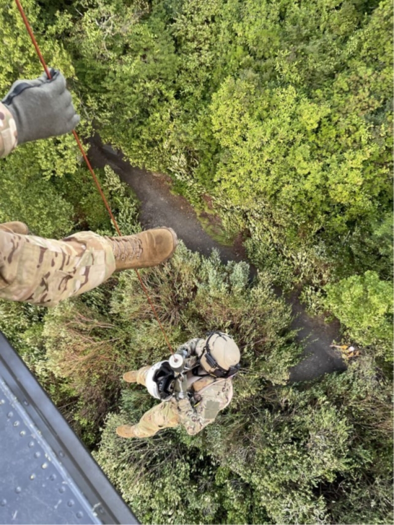 Tennessee National Guard crew chief, Sgt. Christopher Farrar, lowers the flight paramedic, Sgt. 1st Class Giovanni DeZuani, to an injured hiker during a rescue at the Great Smoky Mountains National Park, July 27. (Submitted photo)