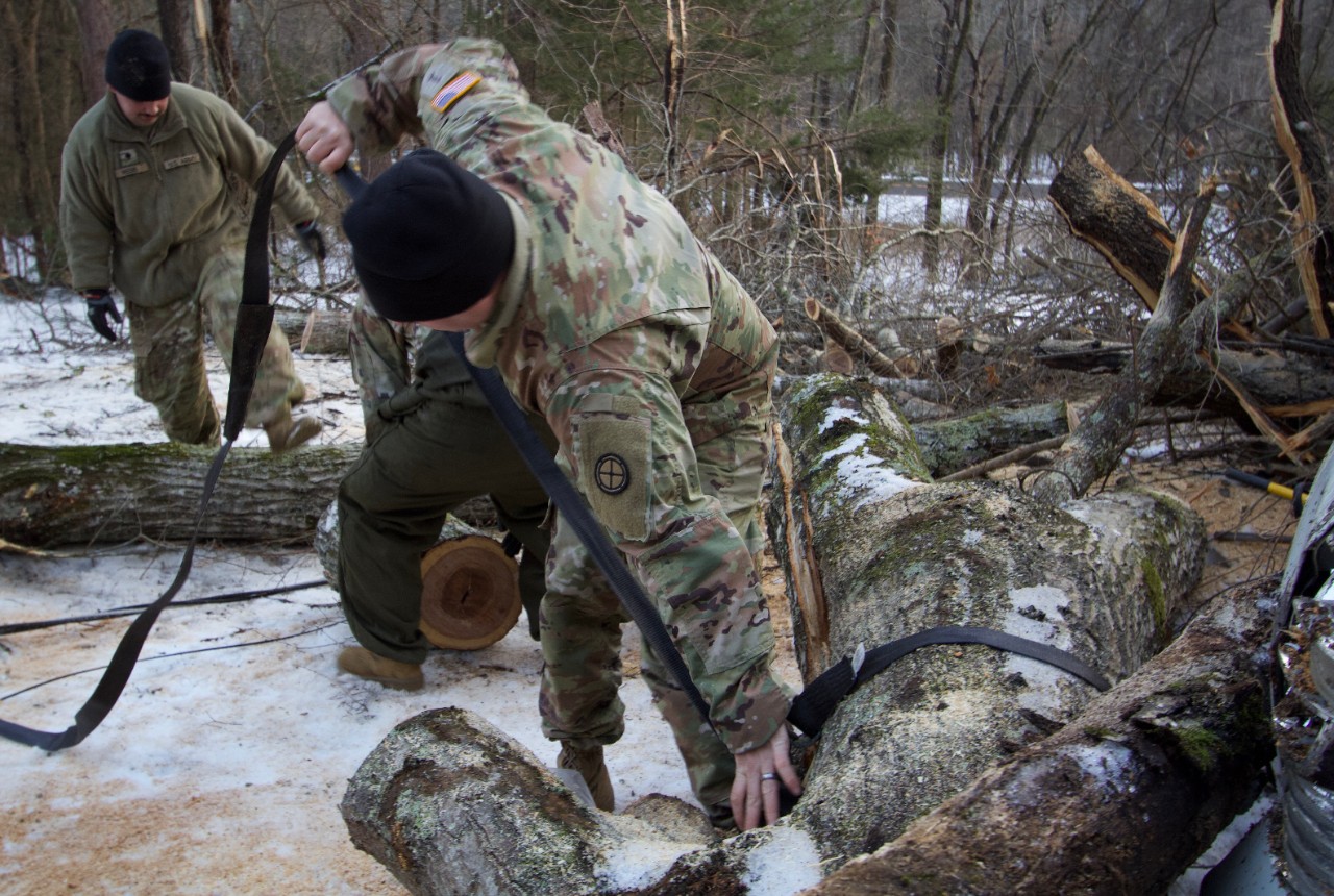 A Soldier with the Tennessee Army National Guard’s 35th Division Sustainment Brigade applies a tow strap to a downed tree to have it removed from the road allowing emergency personnel and electric lineman access to damaged infrastructure in Perry County. Guardsmen are supporting state, county, and local emergency responders as they assist Tennesseans affected by Winter Storm Fern. (photo by Sgt. Maylee Curtis)