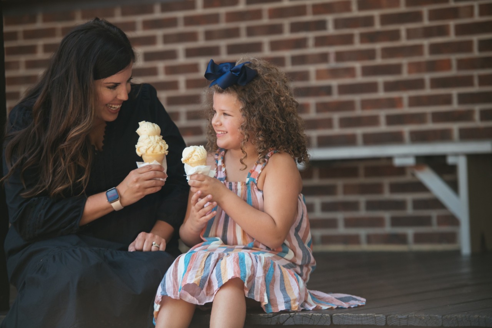 McMinn 1 A woman and a child sit together outdoors, smiling while holding ice cream cones.