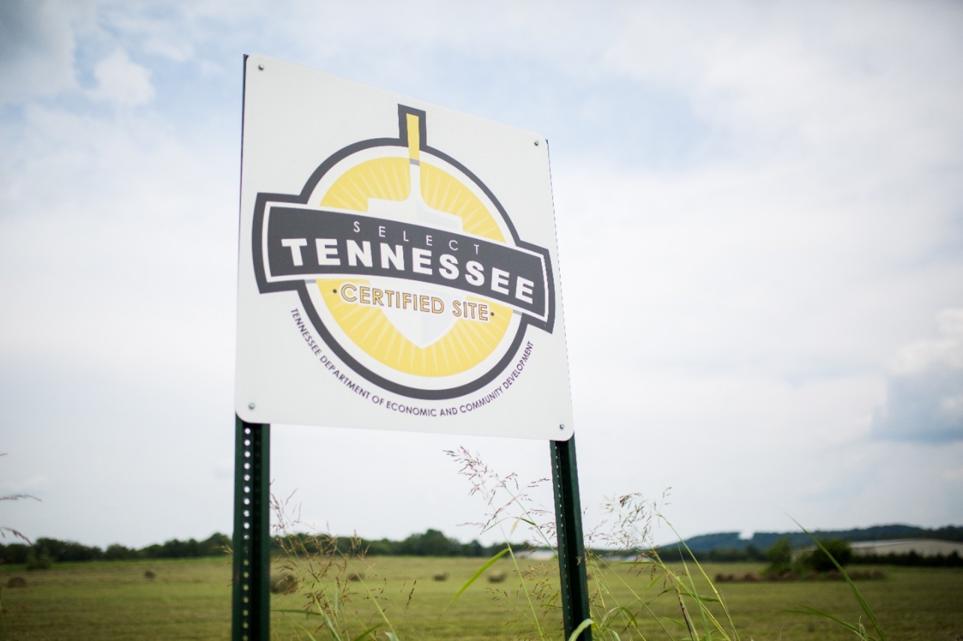 Roadside sign reads “Select Tennessee Certified Site,” displayed in a grassy field under a cloudy sky.