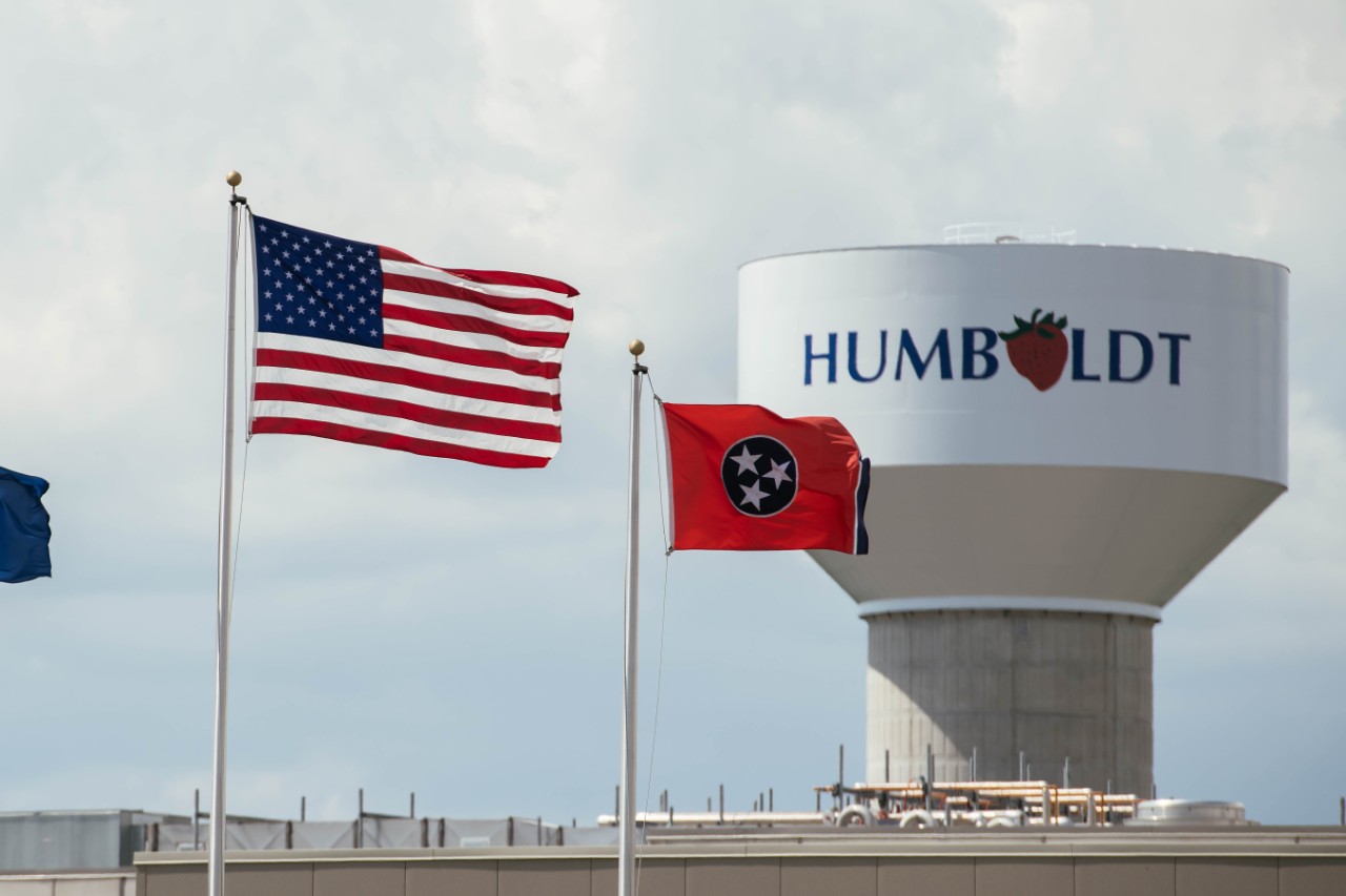 American and Tennessee state flags fly in front of a water tower labeled “Humboldt."