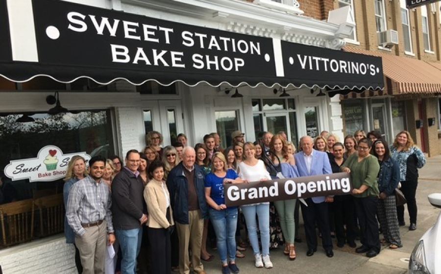Sweetwater Main Street Entrepreneur Grant A group of people stands outside a bakery storefront holding a sign that reads “Grand Opening.”