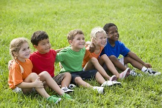 Kids sitting in grass.