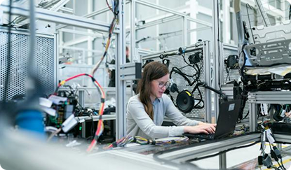 Photo of a woman with glasses on a laptop in a research lab