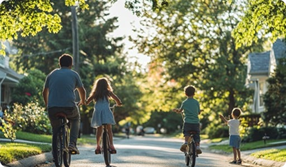 Photo of a family of four riding bikes down a residential street