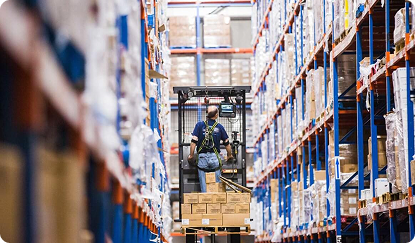 Photo of a worker on a forklift in a warehouse aisle