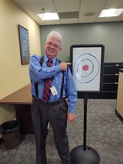 man pointing at target for rubber band archery