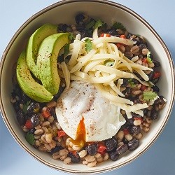 breakfast beans with poached egg in a bowl with avocado and cheese