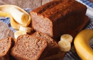 Banana Bread a loaf of banana bread with a sliced banana next to it