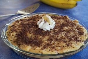a banana cream pie on a blue surface