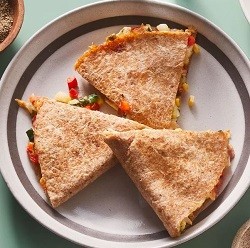 three triangles of a chicken and veggie quesadilla on a plate