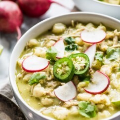 Chicken Pozole Verde in a bowl with jalapeno and radish garnish