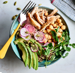 A bowl of chicken, chickpeas, avocado, quinoa and a fork on the side