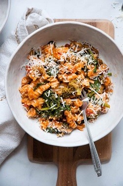 A bowl of pasta with cheese on top