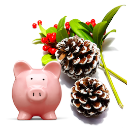 A piggy bank next to holiday holly and a pine cone A piggy bank next to holiday holly and a pine cone