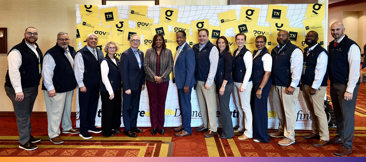 TNWorks A group of 14 people stand in front of a GovCon backdrop to pose for a photo