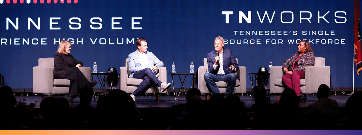 TNWorks Four people sit in chairs on a stage with a backdrop that says TNWorks: Tennessee's Single Source for Workforce