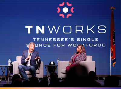Gov. Bill Lee and Commissioner Deniece Thomas sit in chairs on a stage with a backdrop that reads TNWorks: Tennessee's Single Source for Workforce