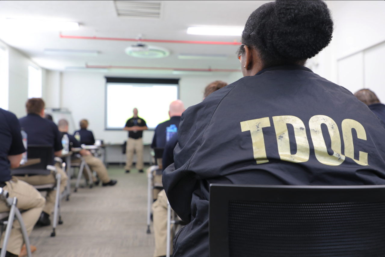 Officer Listening to Instructor Photo of Officer Listening to Instructor in Front of Classroom