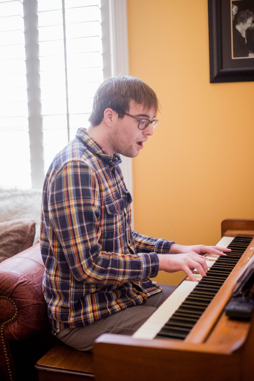 DSC_7801 Ben, a 21yo man, sits at an antique piano singing and playing the keys