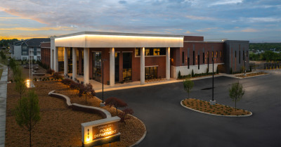 Spring Hill Police Department The modern brick Spring Hill Police Department building with tall white columns supporting a wide, brightly lit entrance canopy.