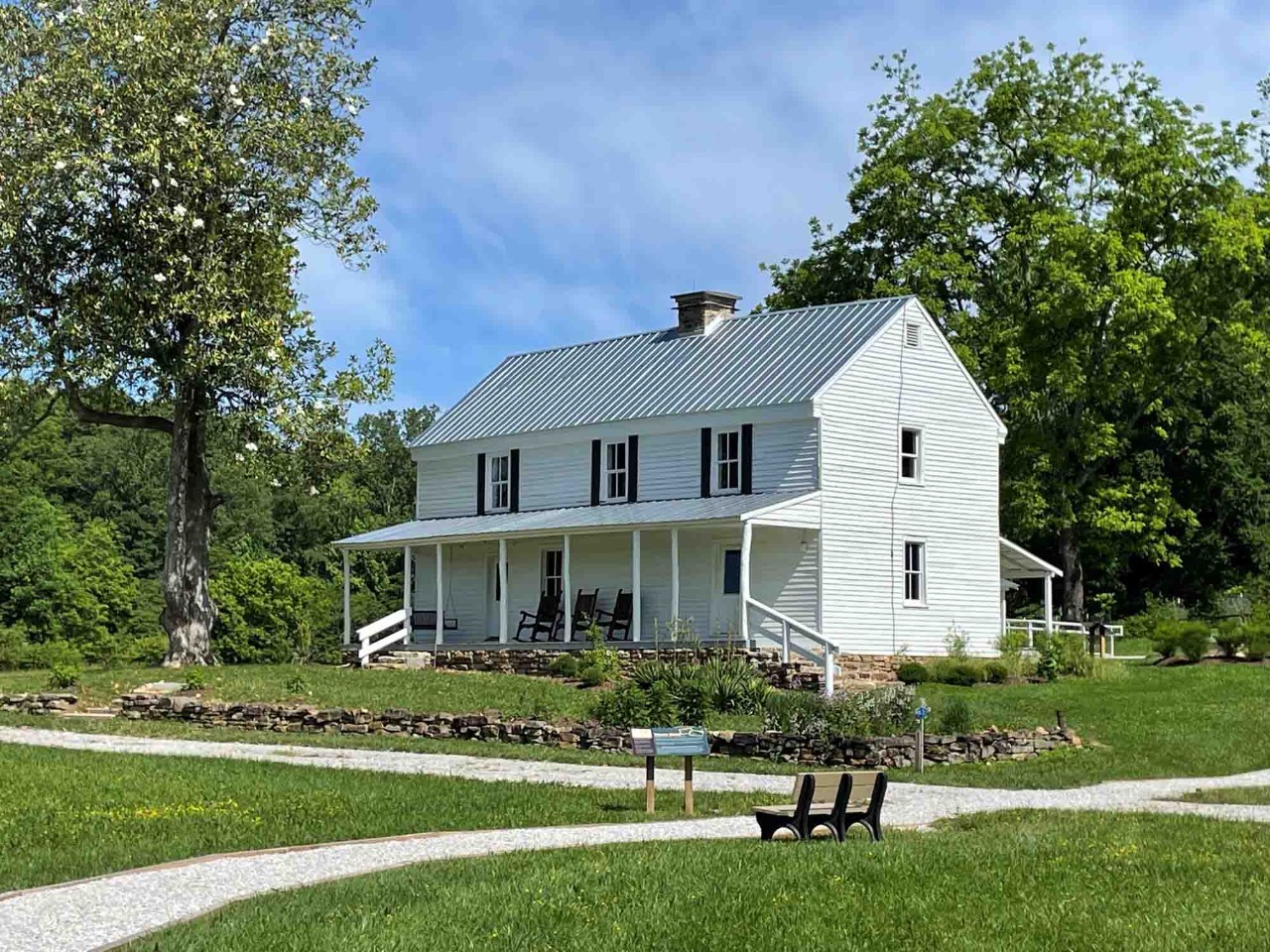 The Stonecipher Kelly House after restoration. Image of The Stonecipher Kelly House after restoration. Image shows a white, 2-story house with a chimney, windows, and covered front and back porches.