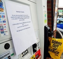 Small picture of a gas pump with a yellow bag stating “Sorry out of service” and a sign over the display alerting customers to a pipeline outage. Small picture of a gas pump with a yellow bag stating “Sorry out of service” and a sign over the display alerting customers to a pipeline outage.