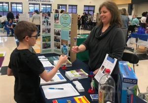 STEMNightChristianaMiddleSchool2 TDEC OEP team member speaking with student at information energy education booth.