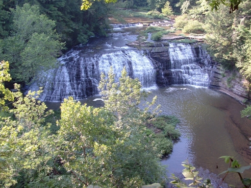A wide waterfall pours into a a river at Burgess Falls