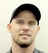 Justin Gillaspie headshot A man wearing a ballcap and has a short beard.