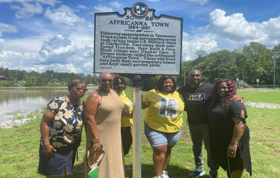 Tennessee Historical Commission Marker Image of a group of six people standing around a gray marker titled "Affricanna Town""