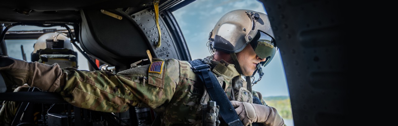 A Tennessee National Guardsmen in uniform looking out of a black hawk helicopter side door