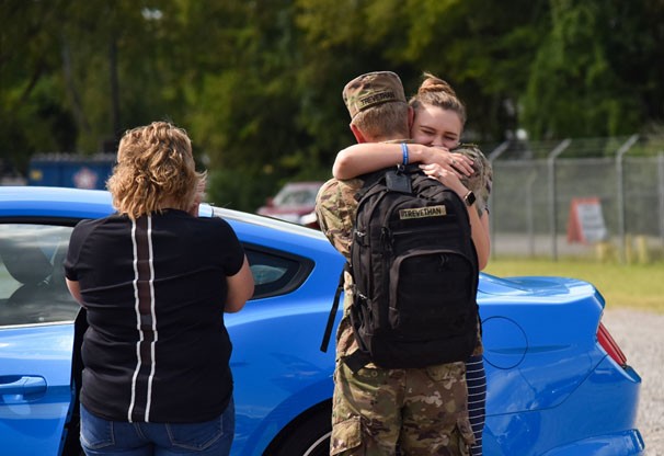 Soldiers from the 194th Engineer Brigade are greeted by loved ones at an improvised, drive-thru homecoming ceremony, in Smyrna, Sept. 17, following a year-long deployment to the middle-east. Soldier hugging family member