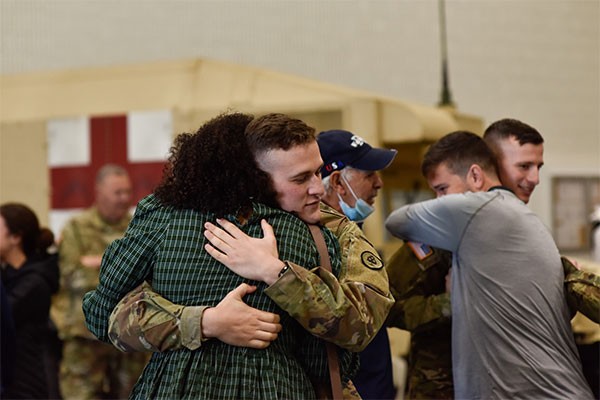 Sgt. Jacob Winton, 208th Medical Company (Area Support), embraces his loved ones during their departure ceremony at Smyrna’s Volunteer Training Site, Dec. 6. The 208th deployed for a yearlong mission to the Middle East in support of Operation Spartan Shield and Operation Inherent Resolve. (Photo by Sgt. 1st Class Timothy Cordeiro)