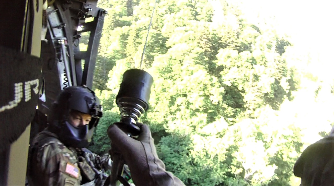 Sgt. Tim Allen begins hoist operations and lowers Sgt. 1st Class Tracy Banta, a Critical Care Flight Paramedic, to a bear attack victim in the Great Smoky Mountain National Park Area, June 18. (Courtesy photo from the Tennessee National Guard)