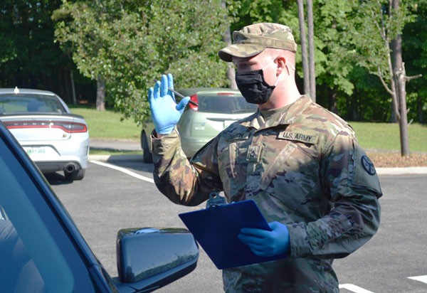 Pfc. William Orton, a cavalry scout assigned to Newport’s O Troop, 4th Squadron, 278th Armored Cavalry Regiment, explains the COVID-19 vaccination process to a resident in Decatur on June 15. Orton has assisted several sites since he joined the COVID-19 Task Force in February. (Photo by Sgt. Finis L. Dailey, III) Pfc. William Orton, a cavalry scout assigned to Newport’s O Troop, 4th Squadron, 278th Armored Cavalry Regiment, explains the COVID-19 vaccination process to a resident in Decatur on June 15. Orton has assisted several sites since he joined the COVID-19 Task Force in February. (Photo by Sgt. Finis L. Dailey, III)