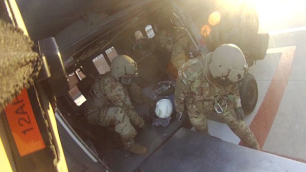 Col. Robert Ross, a fight surgeon for the Tennessee National Guard, helps offload the patient from a UH-60 Blackhawk helicopter at the University of Tennessee Medical Center helicopter pad in Knoxville, Oct. 14. (Photo from the Tennessee National Guard)