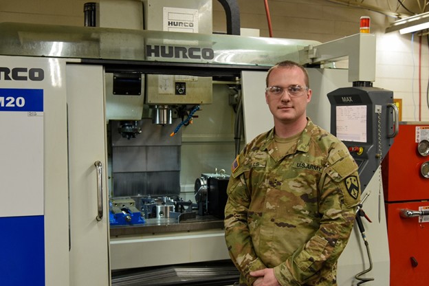 Chief Warrant Officer 2 Joshua Wells says he works for the coolest shop in the Guard. He programs and operates computerized metal fabricating equipment. He is a shop chief at the Volunteer Training Site in Smyrna, Tenn. (Photo by retired Sgt. 1st Class Edgar Castro) Chief Warrant Officer 2 Joshua Wells says he works for the coolest shop in the Guard. He programs and operates computerized metal fabricating equipment. He is a shop chief at the Volunteer Training Site in Smyrna, Tenn. (Photo by retired Sgt. 1st Class Edgar Castro)
