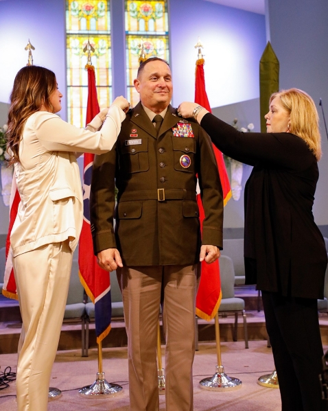 Col. Michael “Trent” Scates is promoted to the rank of brigadier general by his wife, Beth, and his daughter, McCall, during a ceremony held at the First Baptist Church in Greenfield, March 26. (photo by Staff Sgt. Mathieu Perry) Col. Michael “Trent” Scates is promoted to the rank of brigadier general by his wife, Beth, and his daughter, McCall, during a ceremony held at the First Baptist Church in Greenfield, March 26. (photo by Staff Sgt. Mathieu Perry)