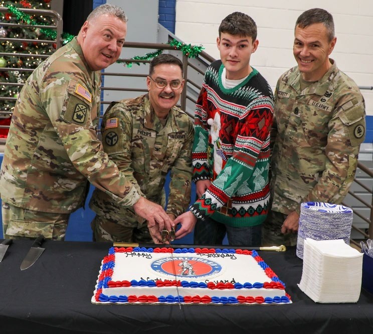 Maj. Gen. Warner Ross, Tennessee’s Adjutant General, Col. Mark Phillips, the senior chaplain for the Tennessee National Guard, Spc. Landon Evans with the 118th Mobile Public Affairs Detachment, and Command Sgt. Maj. Dale Crockett, Tennessee’s Senior Enlisted Leader, perform the ceremonial cake cutting during the National Guard’s 388th birthday celebration at Nashville’s Joint Force Headquarters, Dec. 13. Phillips represented the oldest serving member at the event while Evans represented the youngest. (photo by Sgt. Olivia Gum) Maj. Gen. Warner Ross, Tennessee’s Adjutant General, Col. Mark Phillips, the senior chaplain for the Tennessee National Guard, Spc. Landon Evans with the 118th Mobile Public Affairs Detachment, and Command Sgt. Maj. Dale Crockett, Tennessee’s Senior Enlisted Leader, perform the ceremonial cake cutting during the National Guard’s 388th birthday celebration at Nashville’s Joint Force Headquarters, Dec. 13. Phillips represented the oldest serving member at the event while Evans represented the youngest. (photo by Sgt. Olivia Gum)