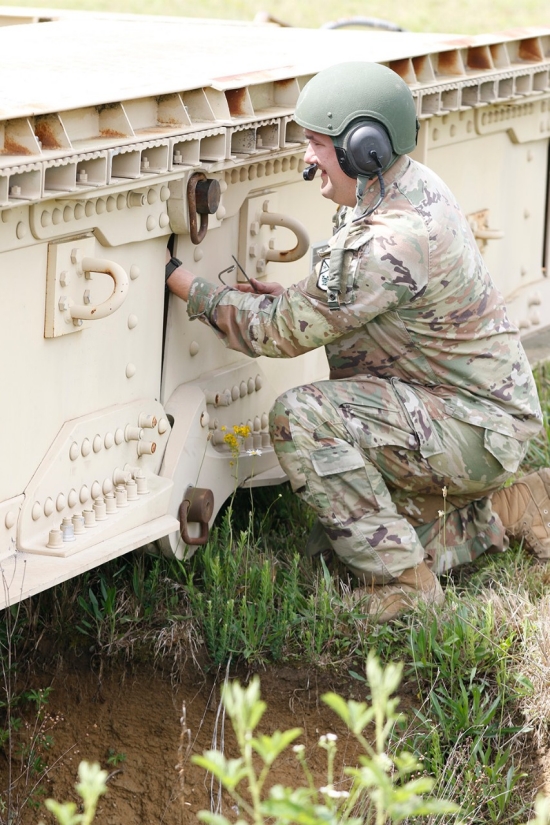 A Tennessee Army National Guard Soldier assigned to the 190th Engineer Company installs a locking pin on the bridge of an M60 Armored Vehicle Launch Bridge over a simulated flooding stream at the Volunteer Training Site in Tullahoma, Saturday, May 18. The training exercise, which focused on the company’s ability to rapidly deploy and set up the M60 bridge, was part of the unit’s ongoing preparation for potential natural disaster response missions. (U.S. Army National Guard photo by Sgt. First Class Mathieu Perry) A Tennessee Army National Guard Soldier assigned to the 190th Engineer Company installs a locking pin on the bridge of an M60 Armored Vehicle Launch Bridge over a simulated flooding stream at the Volunteer Training Site in Tullahoma, Saturday, May 18. The training exercise, which focused on the company’s ability to rapidly deploy and set up the M60 bridge, was part of the unit’s ongoing preparation for potential natural disaster response missions. (U.S. Army National Guard photo by Sgt. First Class Mathieu Perry)