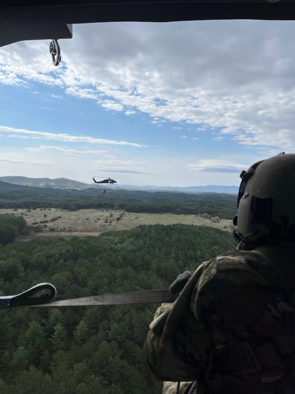Soldiers from Knoxville’s 1-230th Assault Helicopter Battalion prepare to drop water from a Bambi Bucket to combat a wildfire near Turtletown, in Polk County, April 15. Bambi Buckets are used to provide hundreds of gallons of water from local area water sources to combat wildfires. (submitted photo)