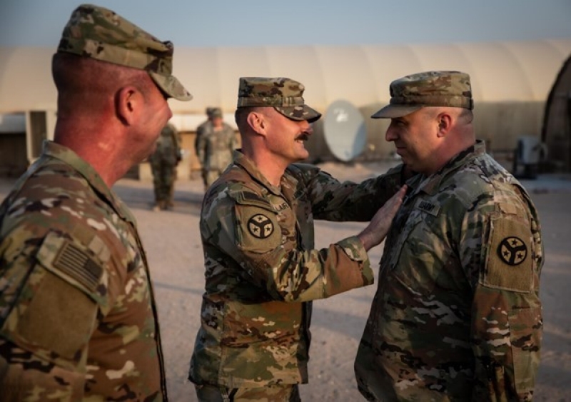 Photo of Staff Sgt. George Brimer, a Jefferson City resident and intelligence analyst with 2nd Squadron, 278th Armored Cavalry Regiment, has his new rank pinned on by Capt. Jason Sieber, during his promotion ceremony in Kuwait on Dec. 20, 2024.