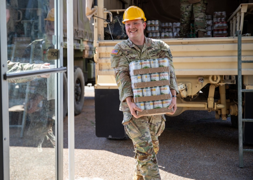Spc. Dylan Wade, with the 913th Engineer Construction Company, carries cases of supplies into the Obion City Community Center, April 7. During the severe flooding in Obion County, Wade supported state and local emergency responders after storms and tornadoes tore through West and Middle Tennessee. (photo by Spc. Landon Evans) Spc. Dylan Wade, with the 913th Engineer Construction Company, carries cases of supplies into the Obion City Community Center, April 7. During the severe flooding in Obion County, Wade supported state and local emergency responders after storms and tornadoes tore through West and Middle Tennessee. (photo by Spc. Landon Evans)